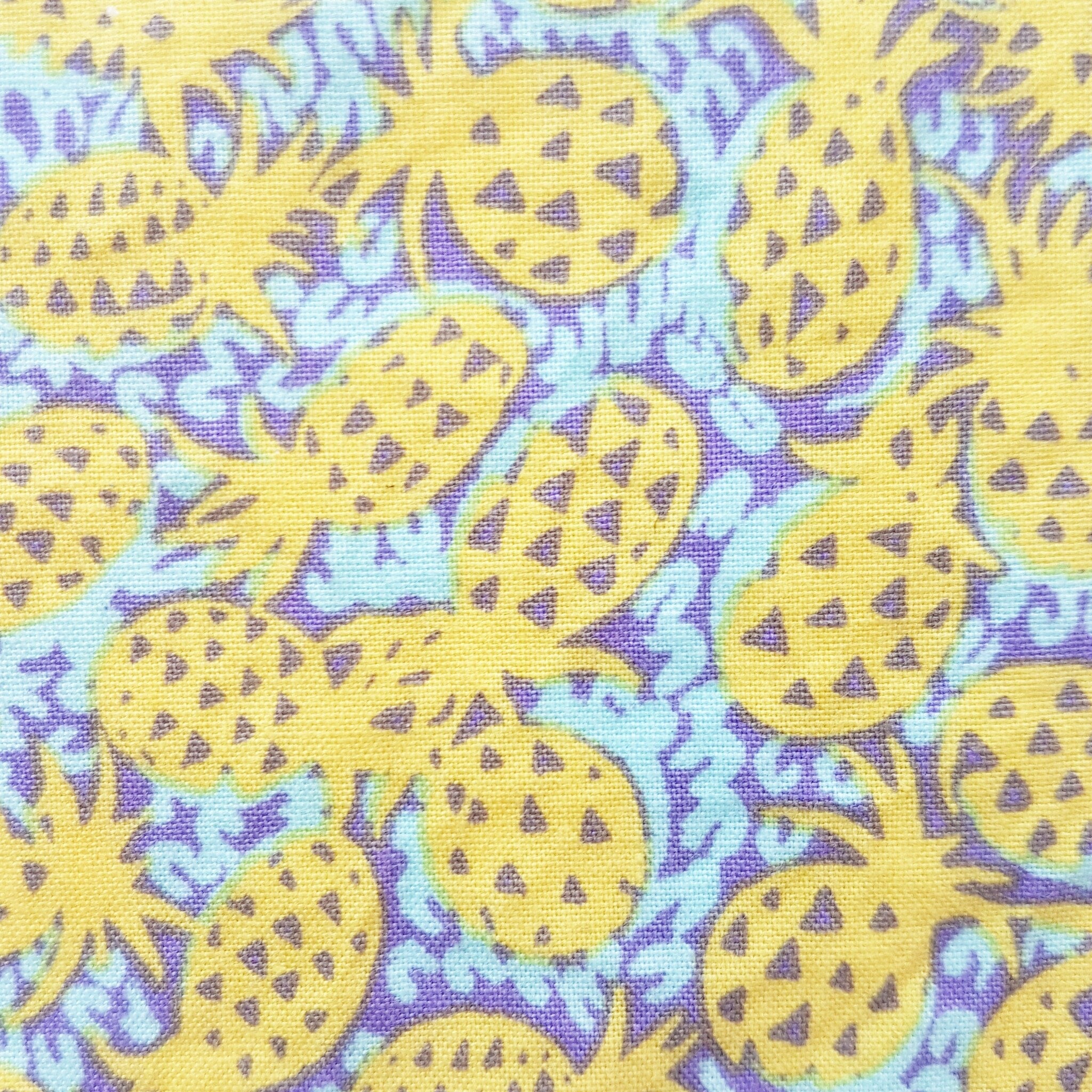 Pineapple pattern fabric in yellow, purple, and light blue colors with a textured appearance