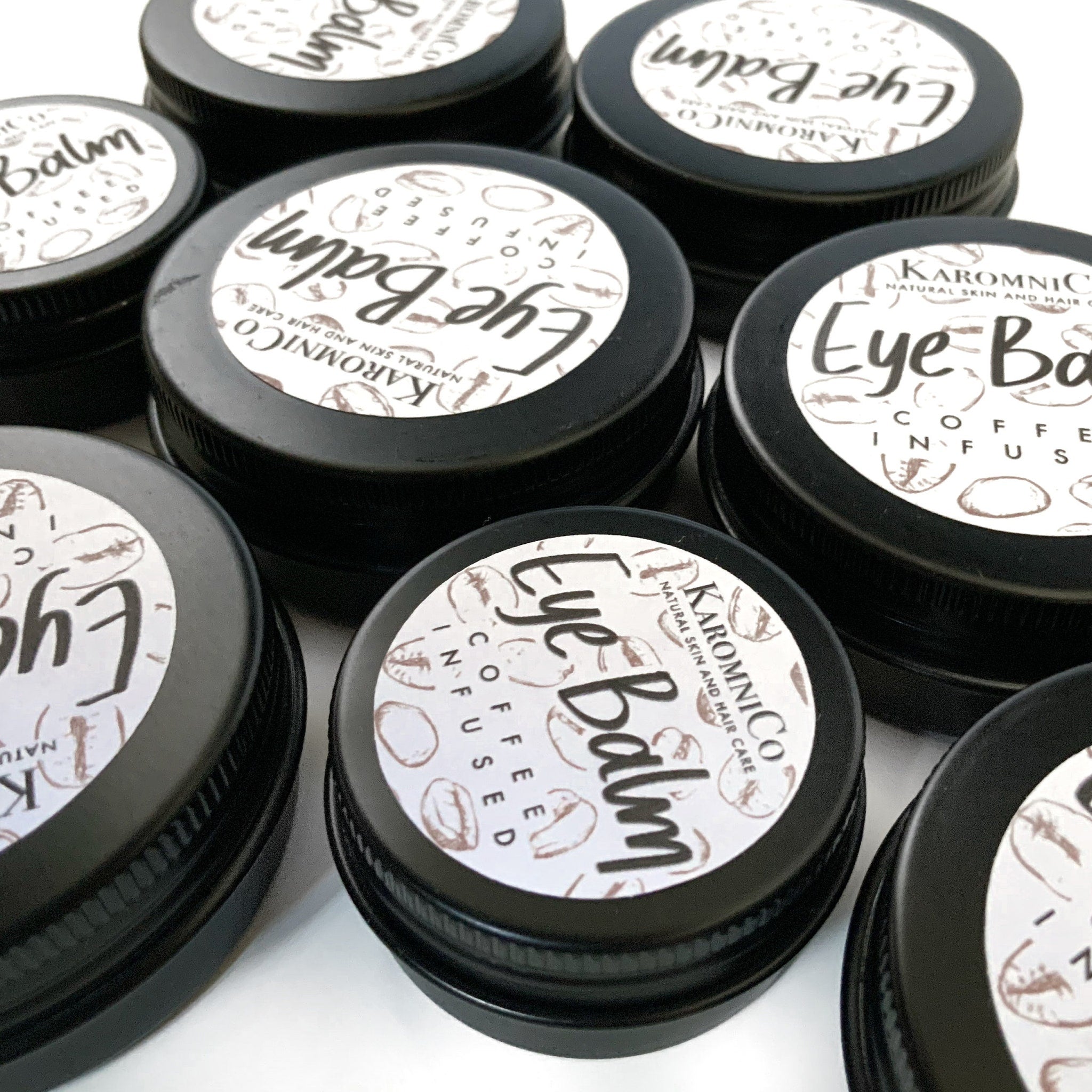Eye Balm in black metal tins with white labels and coffee bean pattern, Karomnico brand visible