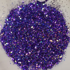 Side view of vibrant purple glitter eye shadow gel pot with metallic lid catching light