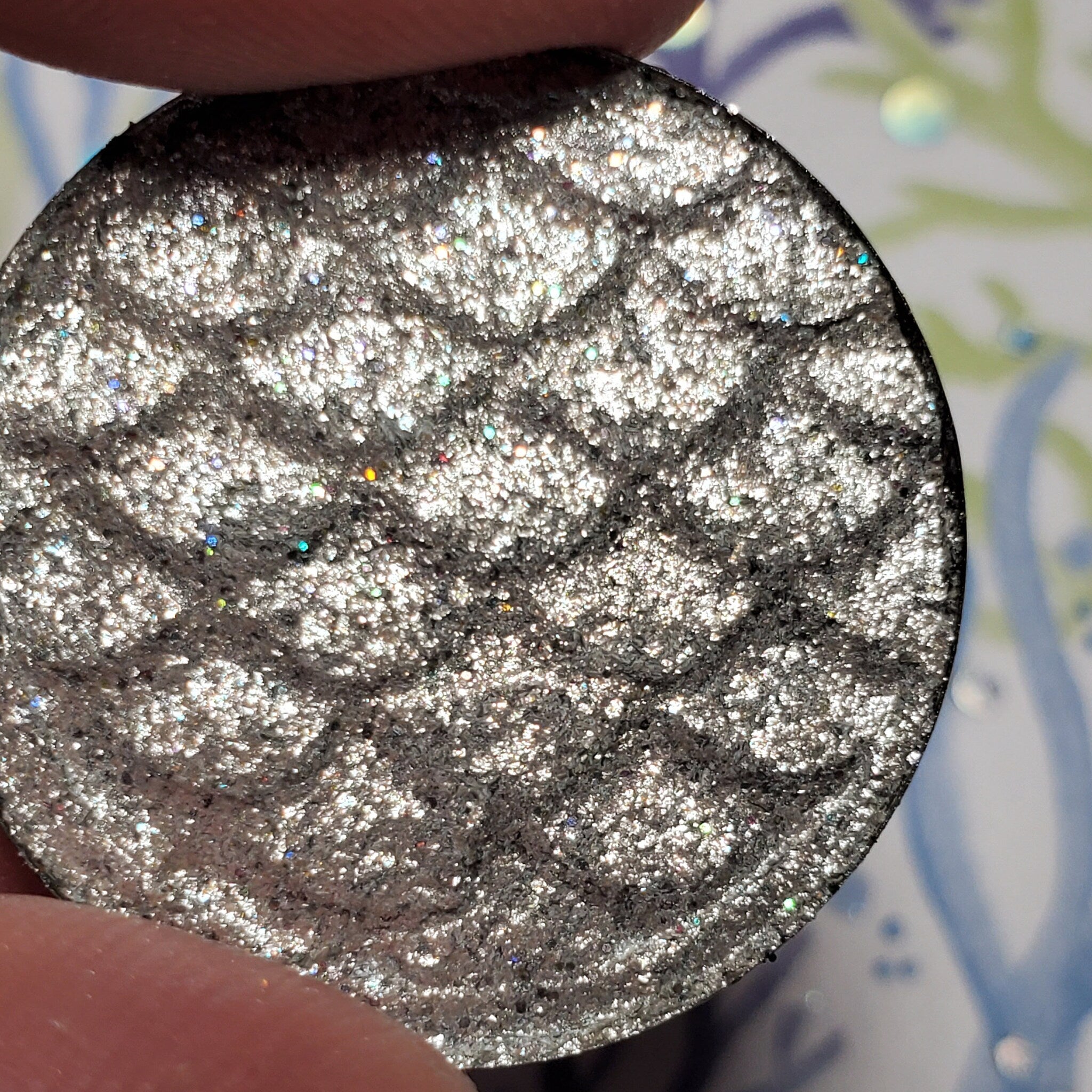Side view of elegant eye shadow palette showcasing shimmering neutral tones in sleek black compact