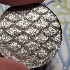 Side view of elegant eye shadow palette showcasing shimmering neutral tones in sleek black compact