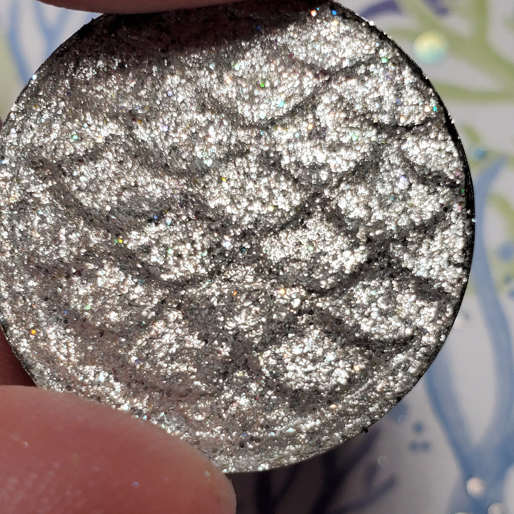 Close-up of shimmering bronze and taupe eye shadow pans with smooth satin finish in sleek black palette
