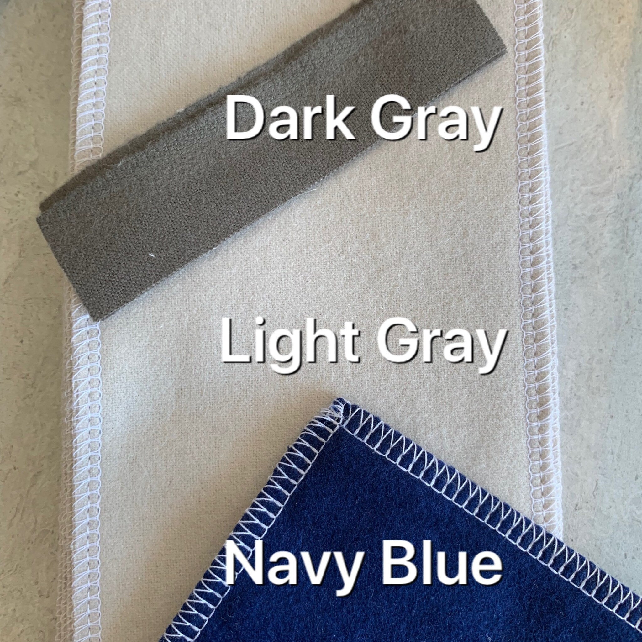 Fabric swatches in dark gray, light gray, and navy blue with white stitching detail