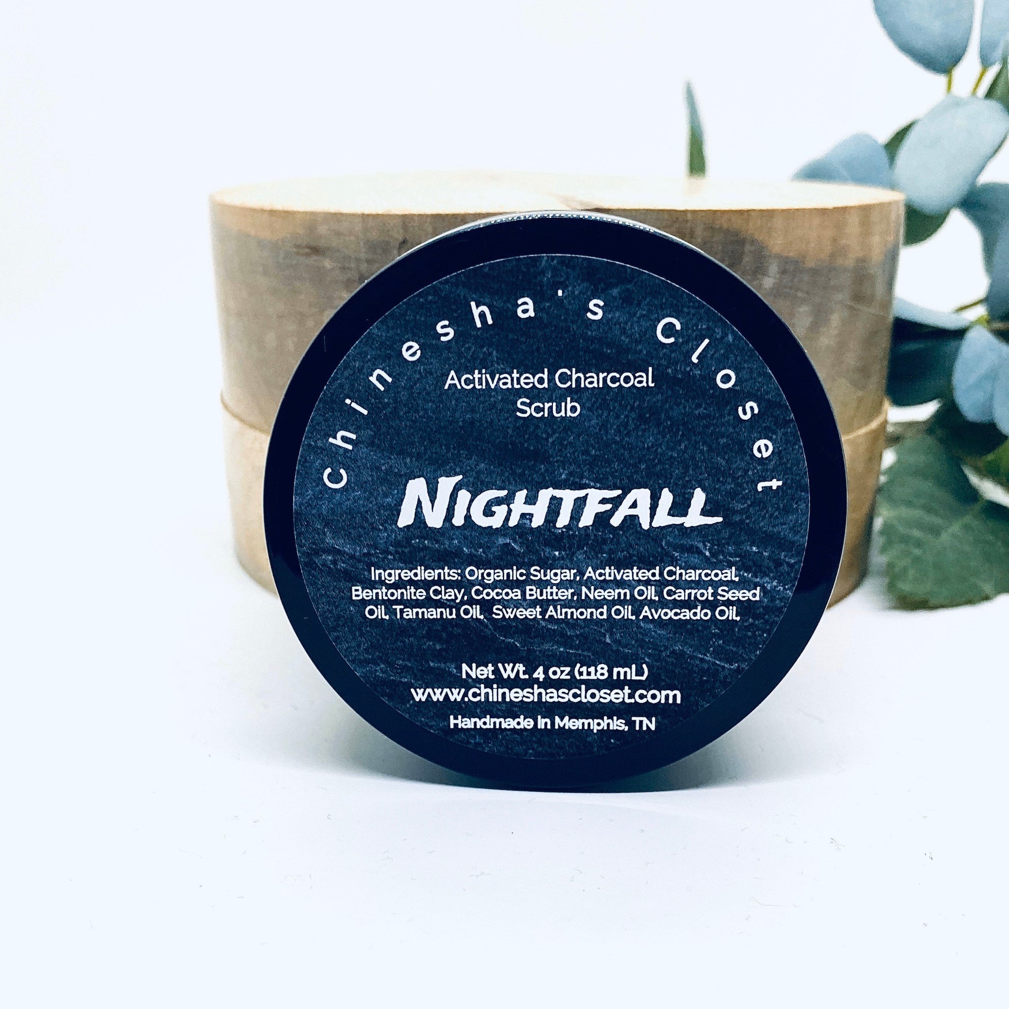 Activated charcoal scrub jar, black label with NIGHTFALL text, wooden background