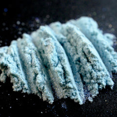 Side view of La Sirena Aqua Eye Shadow duo showing turquoise and orange iridescent shimmer in compact case