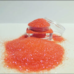 Hand applying loose glitter eyeshadow with a brush, showcasing vibrant shimmer on eyelid