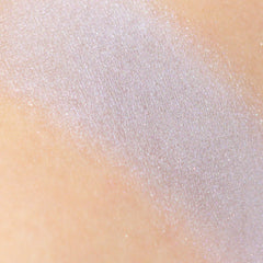 Side angle of frosty silver-gray eyeshadow pan with lavender shimmer, showcasing mineral texture and vegan makeup details