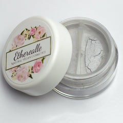 Close-up of frosty silver-gray eyeshadow with shimmering lavender sparkles in compact pan