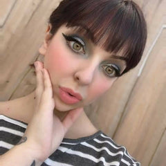 Hand applying shimmery teal and silver mermaid scales eye shadow with a blending brush