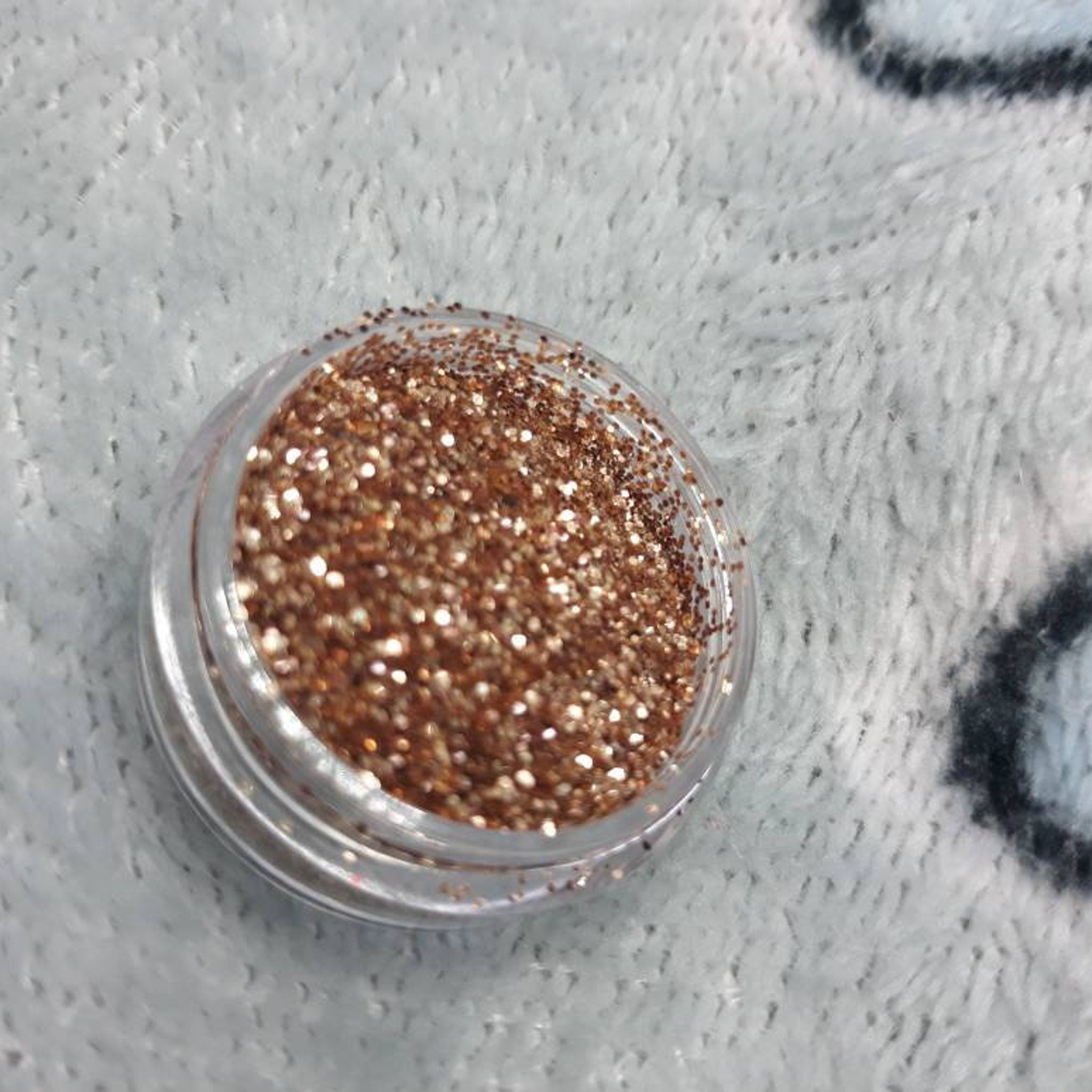 Close-up swatch of Deception Eye Shadow showing rich metallic bronze pigment with smooth satin finish