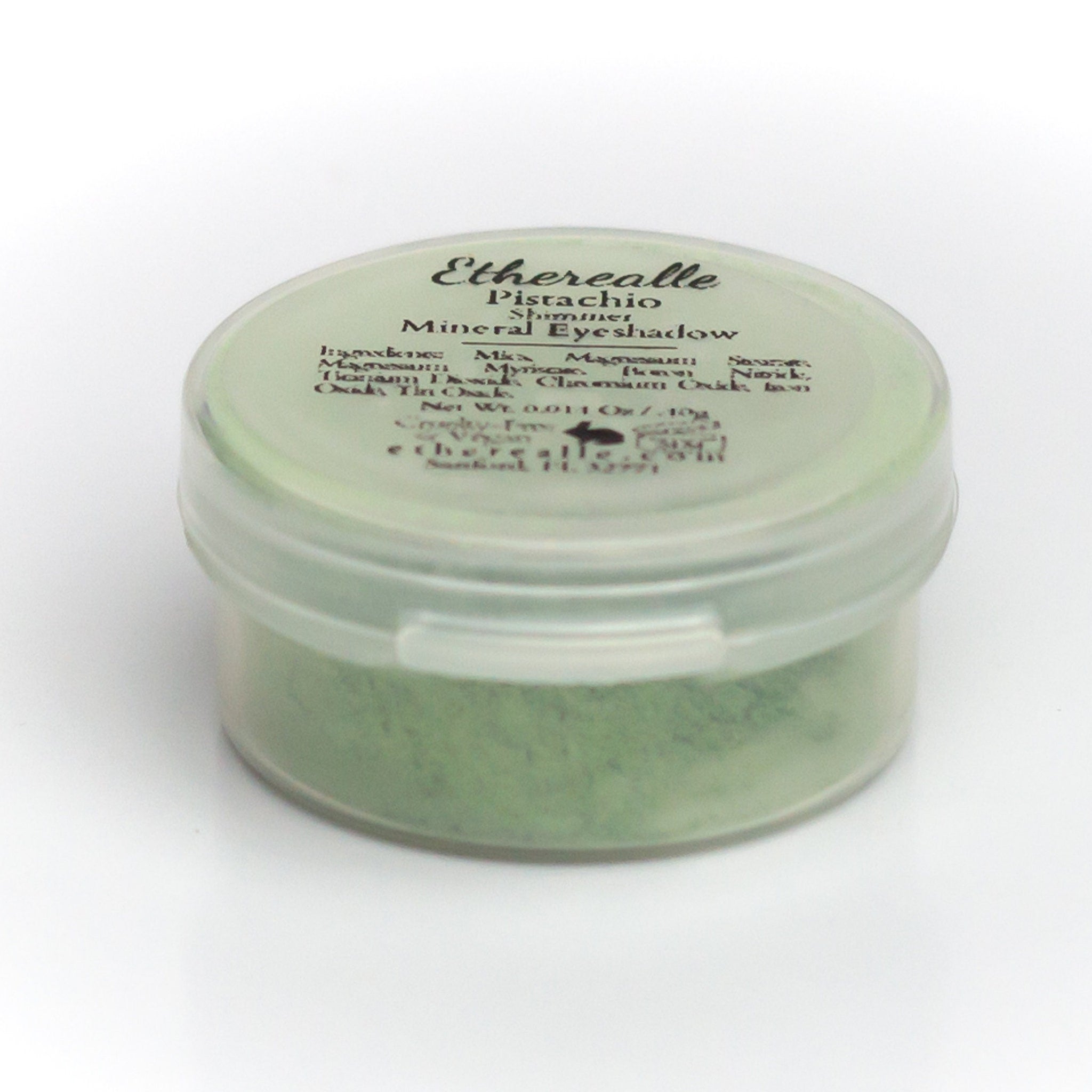 Close-up of shimmery pistachio green eyeshadow pan showing mineral texture and light-reflecting particles