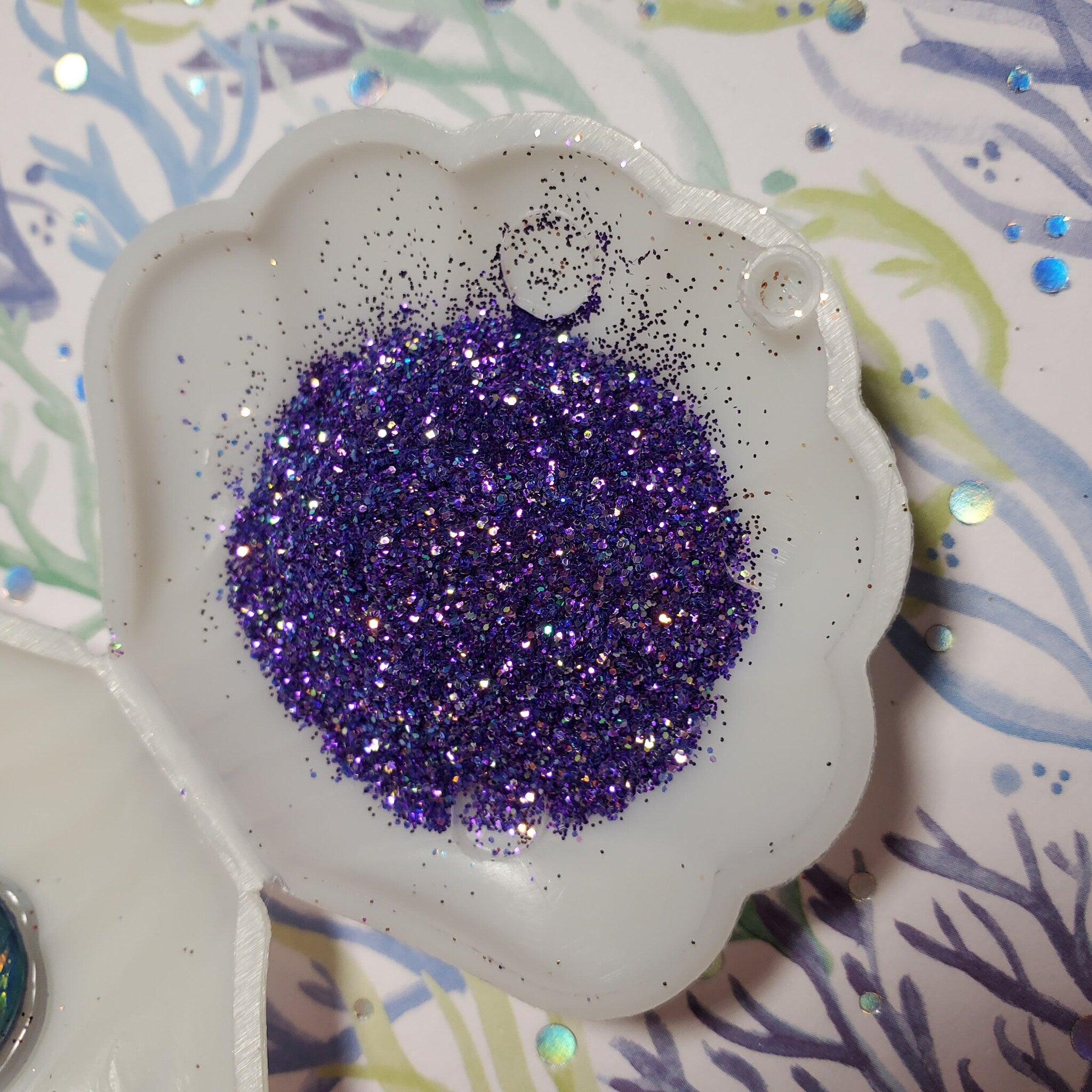 Psylocke glitter eye shadow gel pot displayed open with vibrant shimmer pigment visible inside