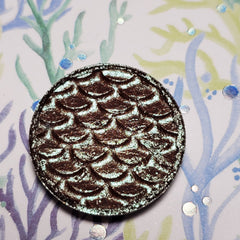 Kelpie Eye Shadow compact in shimmering taupe with sleek black case and gold logo