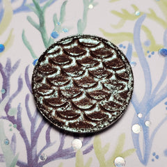 Close-up of Kelpie Eye Shadow pan showing shimmering taupe pigment with smooth satin finish