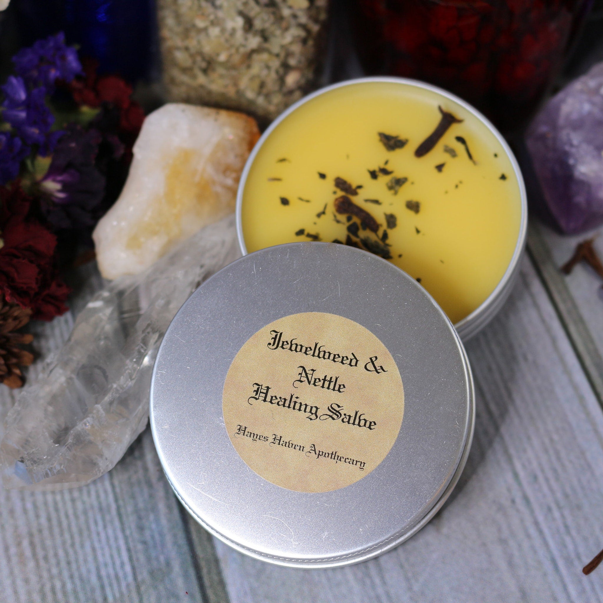 Healing Salve in metal tin with yellow balm, green herbs, and Hayes Haven Apothecary label