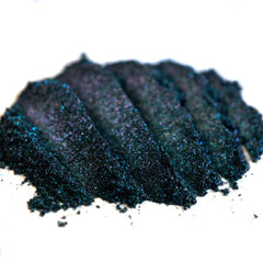 Close-up of iridescent teal eyeshadow applied on eyelid with colorshifting glitter in natural daylight