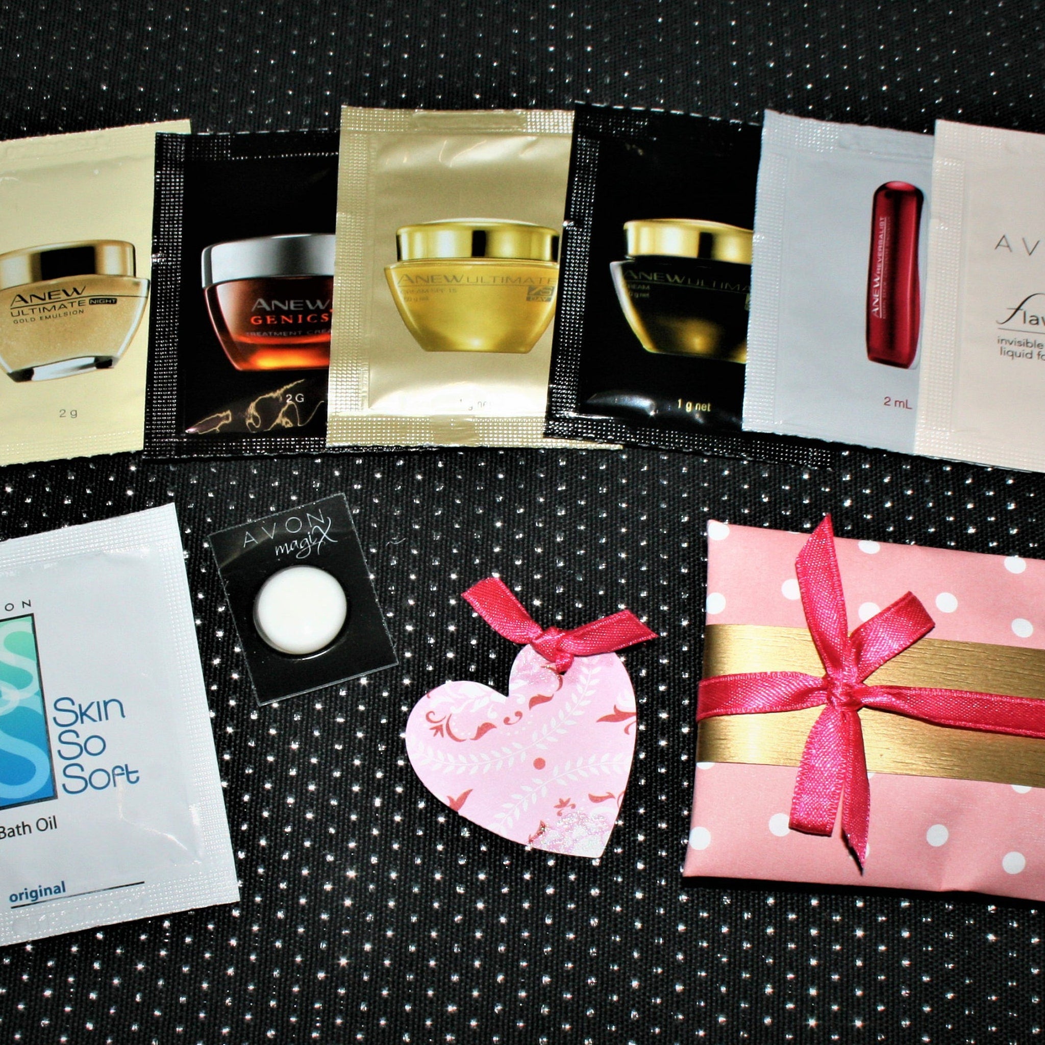 Avon sample pack with pink gift wrap, red ribbon, and polka dot pattern