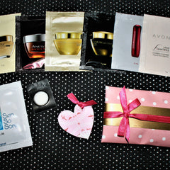 Skincare samples with black, white, and gold packaging, plus pink heart and gift wrap with ribbon