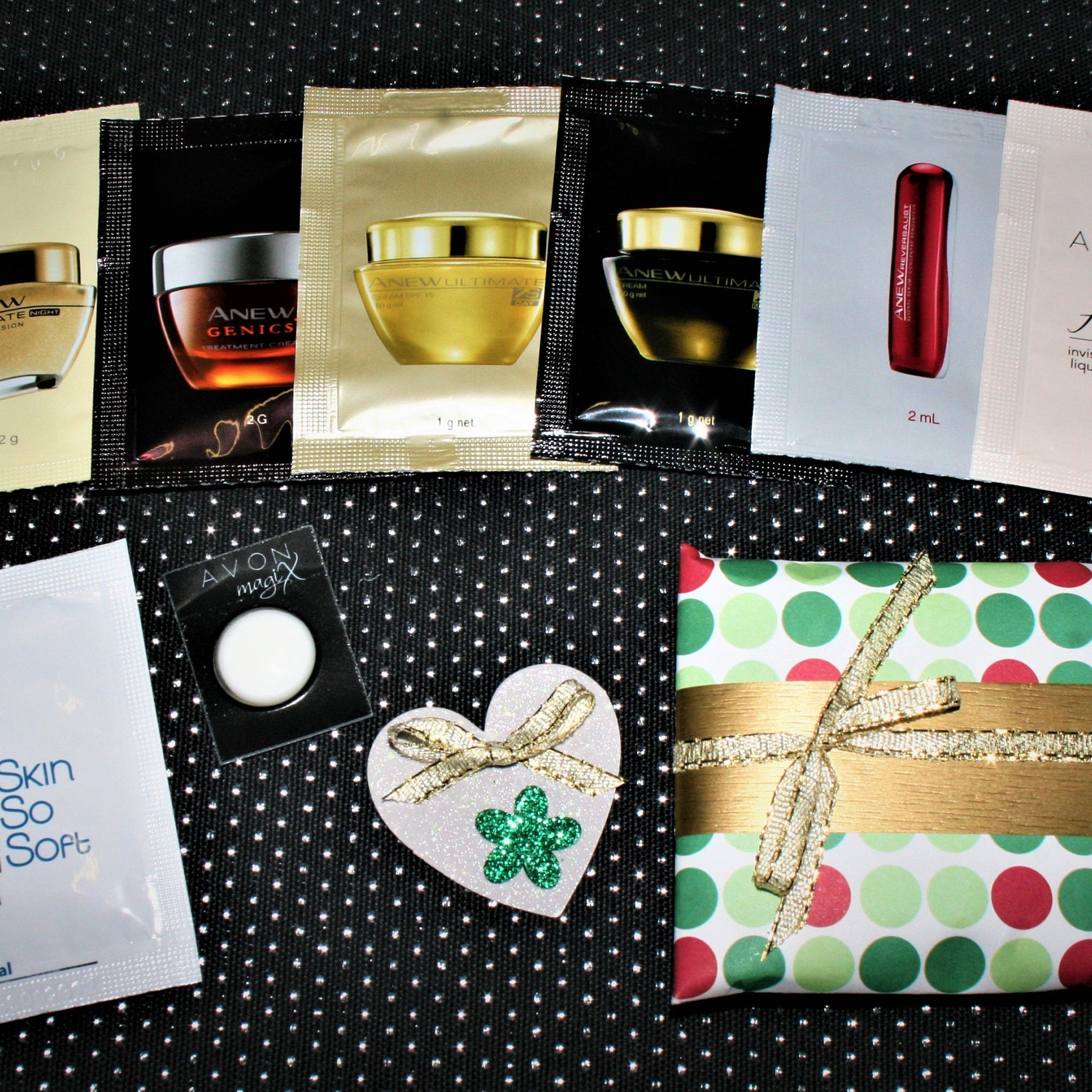 Skincare samples with black, gold, and white packaging, and Avon magix with a white circle