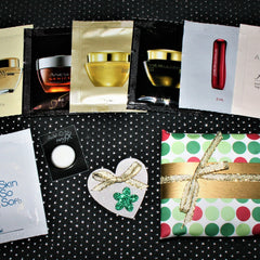 Skincare samples with black, gold, and white packaging, and Avon magix with a white circle