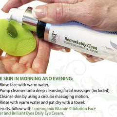 Facial cleanser bottle with white and silver pump, green silicone face massager, and "Remarkably Clean" text