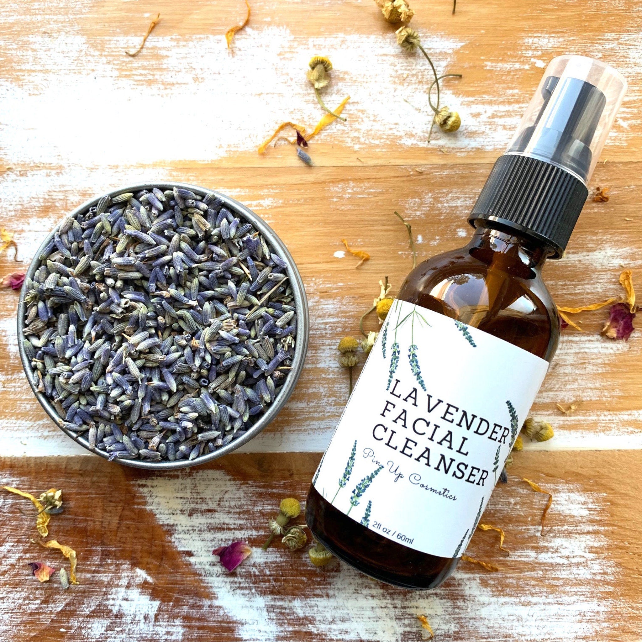 Lavender Facial Cleanser bottle, brown glass, black pump, white label with brand name and text, on wood surface