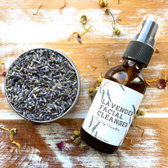 Lavender Facial Cleanser bottle, brown glass, black pump, white label with brand name and text, on wood surface