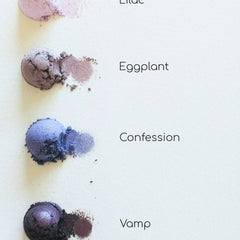 Eyeshadow swatches in purple, blue, and brown hues on white background