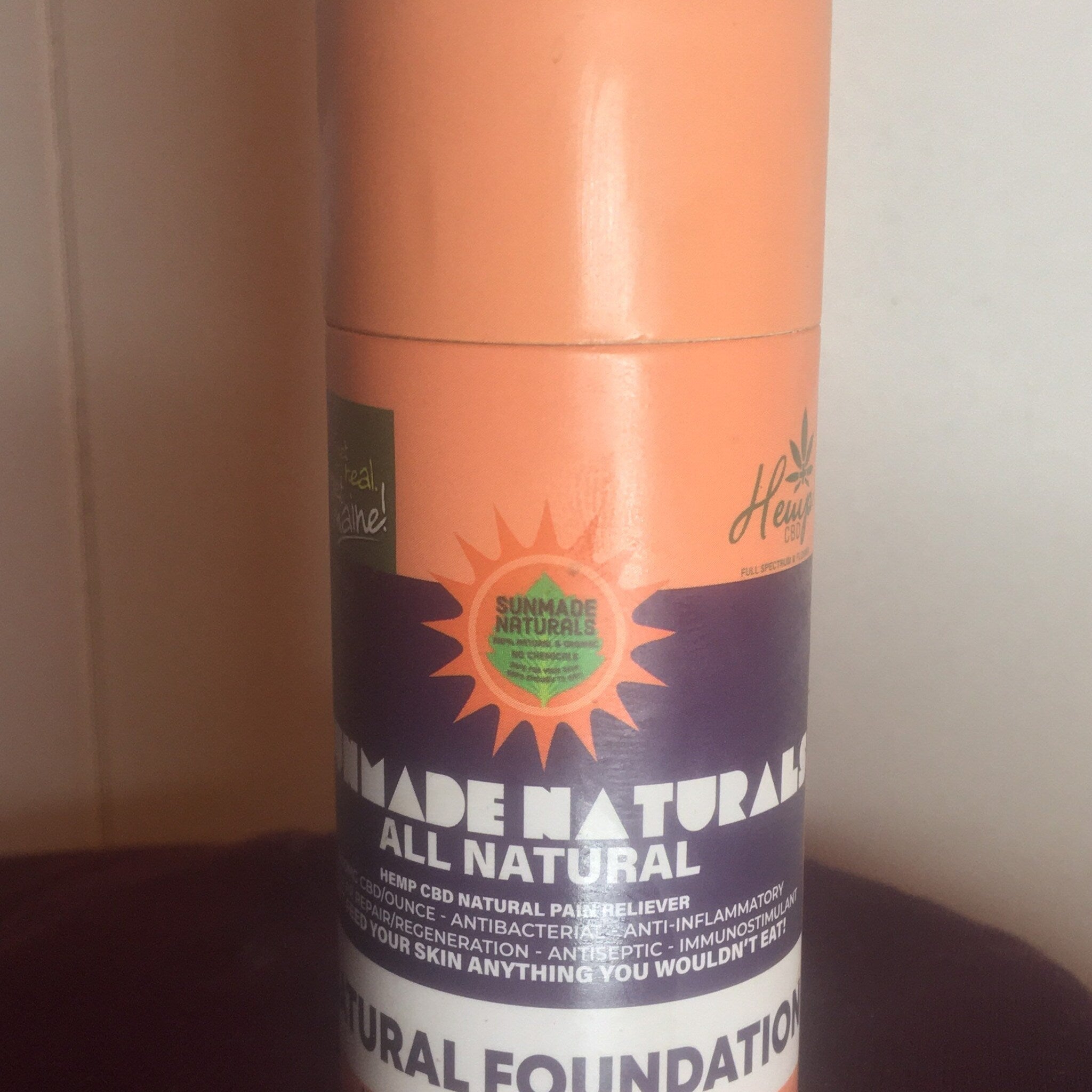 Sunmade Naturals foundation tube, orange and purple with white text, Hemp CBD pain reliever label