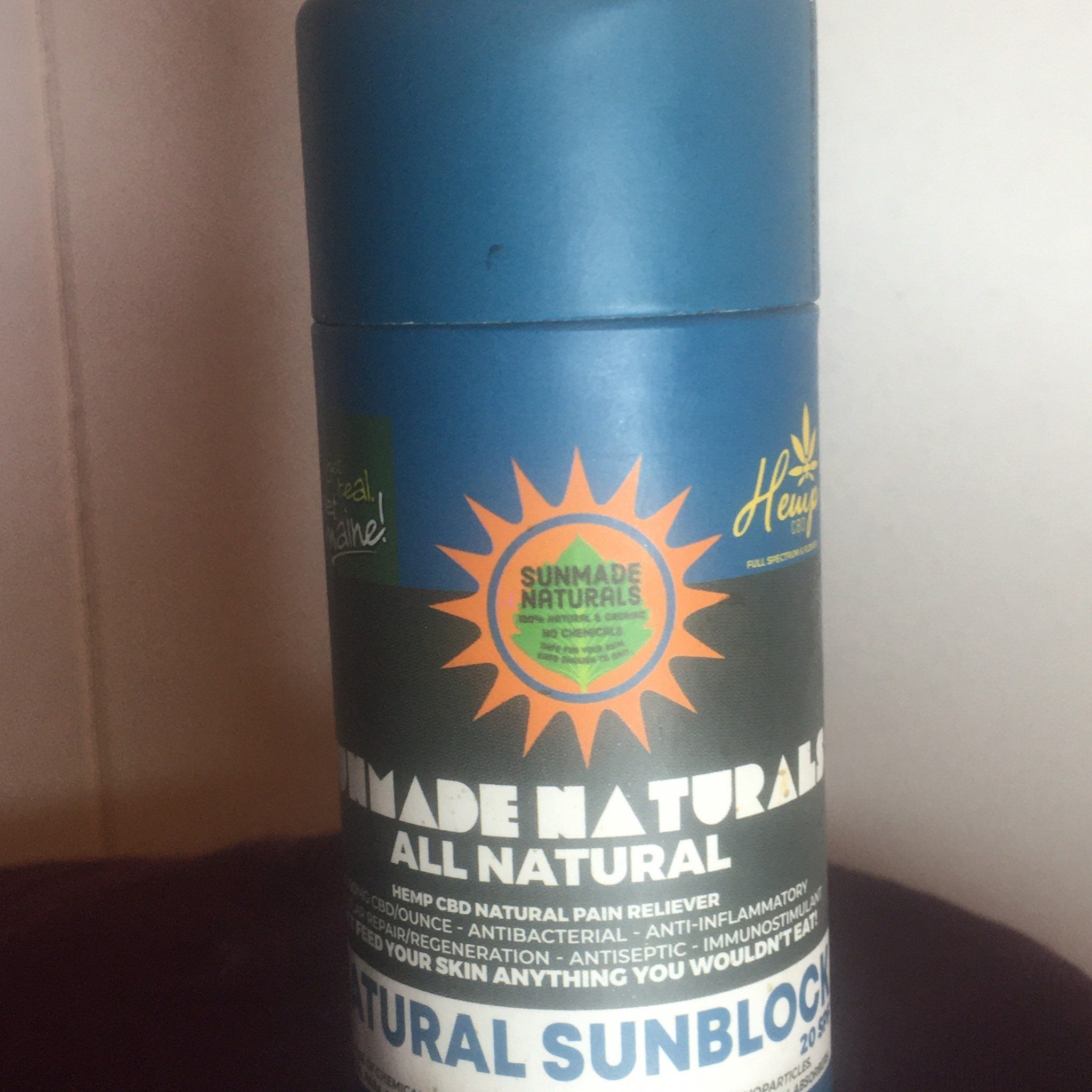 Sunblock bottle, blue and black with orange and green logo, for sun protection