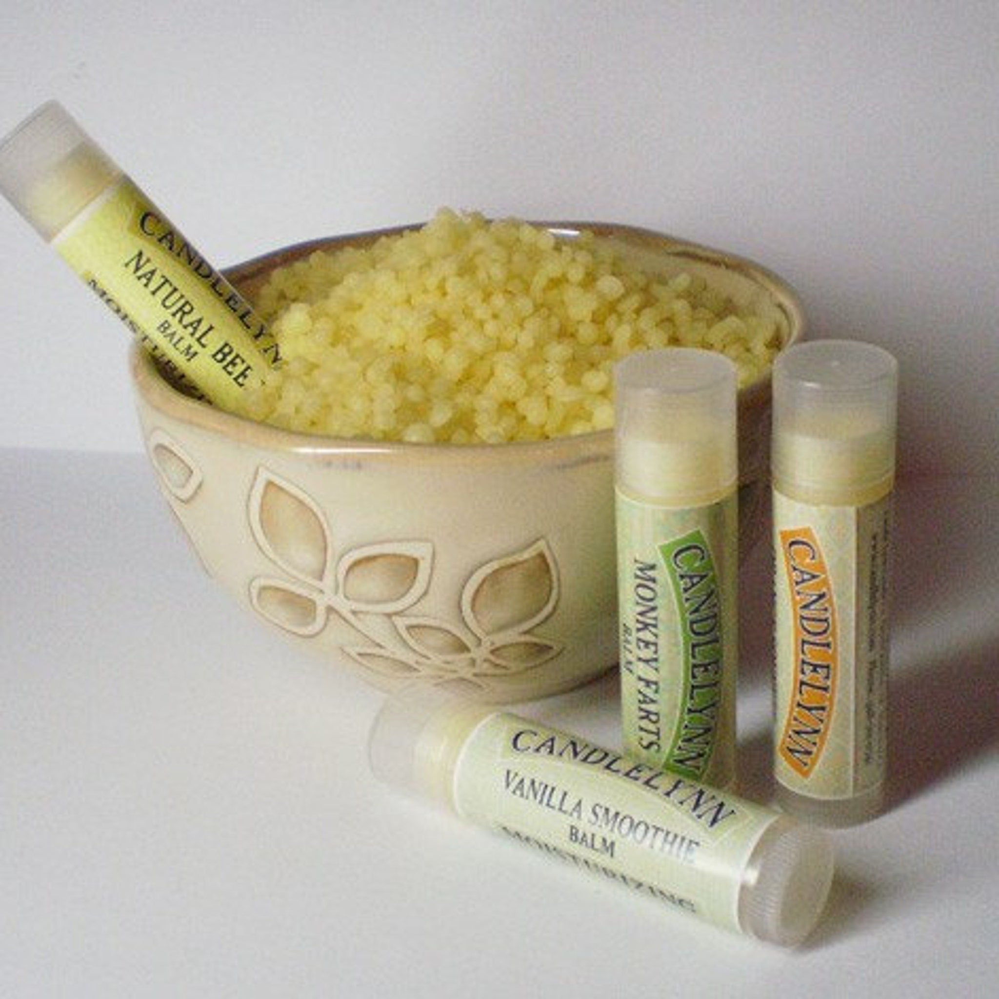 Lip balms with green and yellow labels, Candle Lynn branding, and clear caps