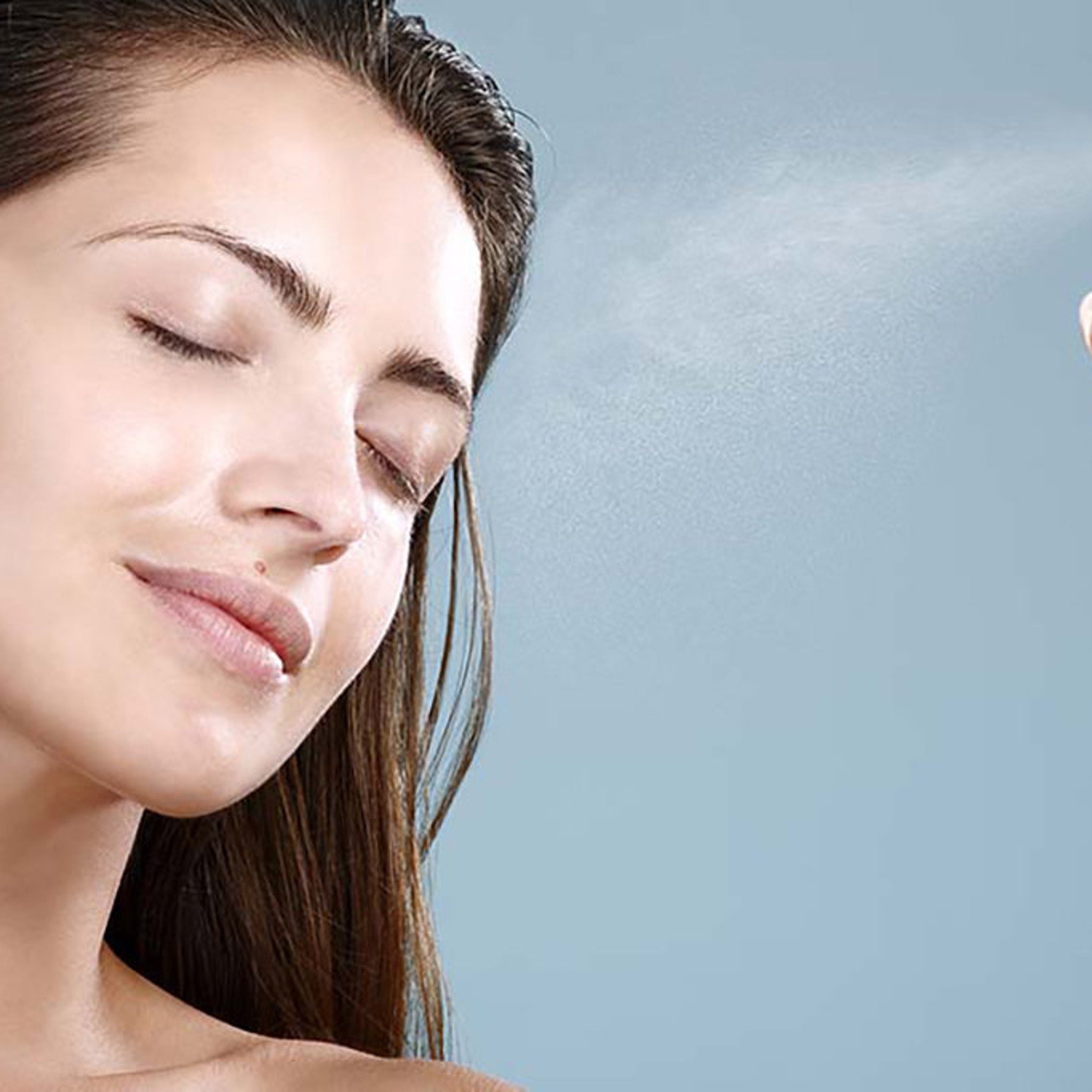 Woman with closed eyes, brown hair, and blue background with mist spraying