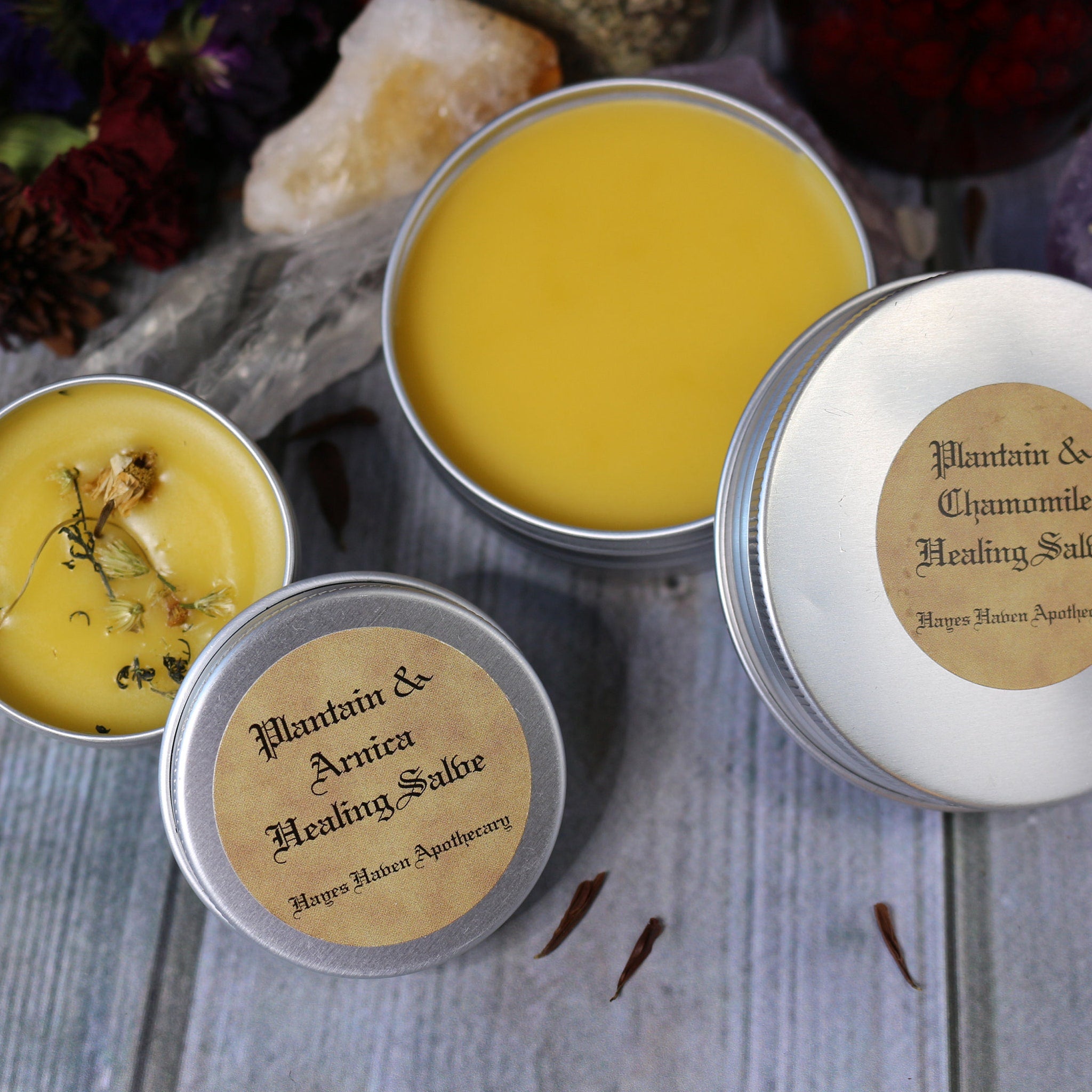 Healing salve tins with yellow balm, silver metal, and Hayes Haven Apothecary label