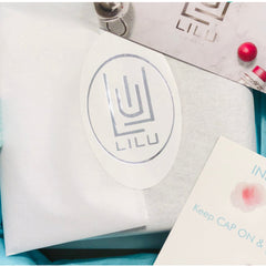 LILU branded oval sticker with silver logo on white paper, packaging with instructions