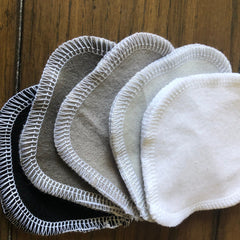 Reusable facial rounds in various colors with white stitched edges and soft material