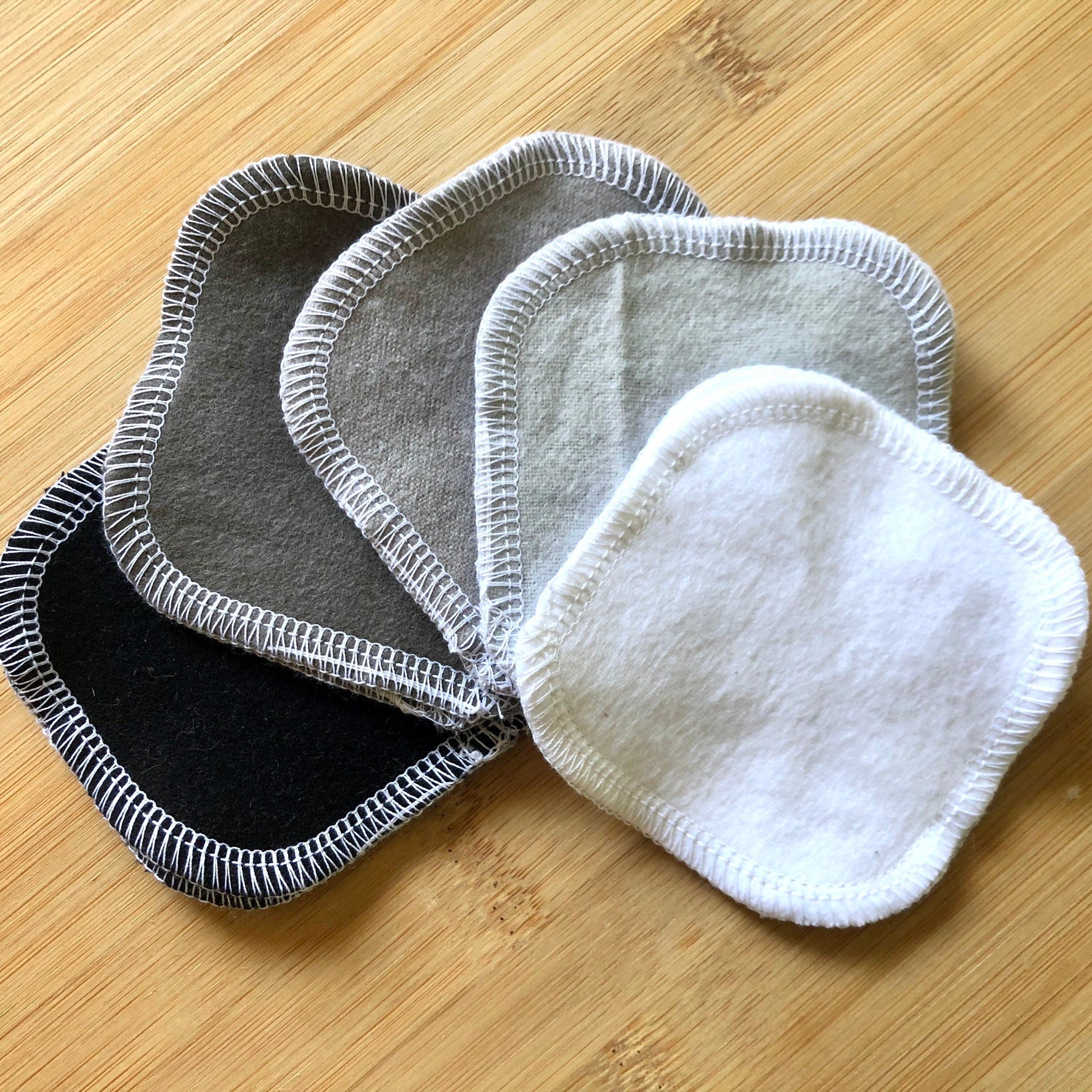 Reusable facial rounds in various colors, white stitching, soft material, stacked together