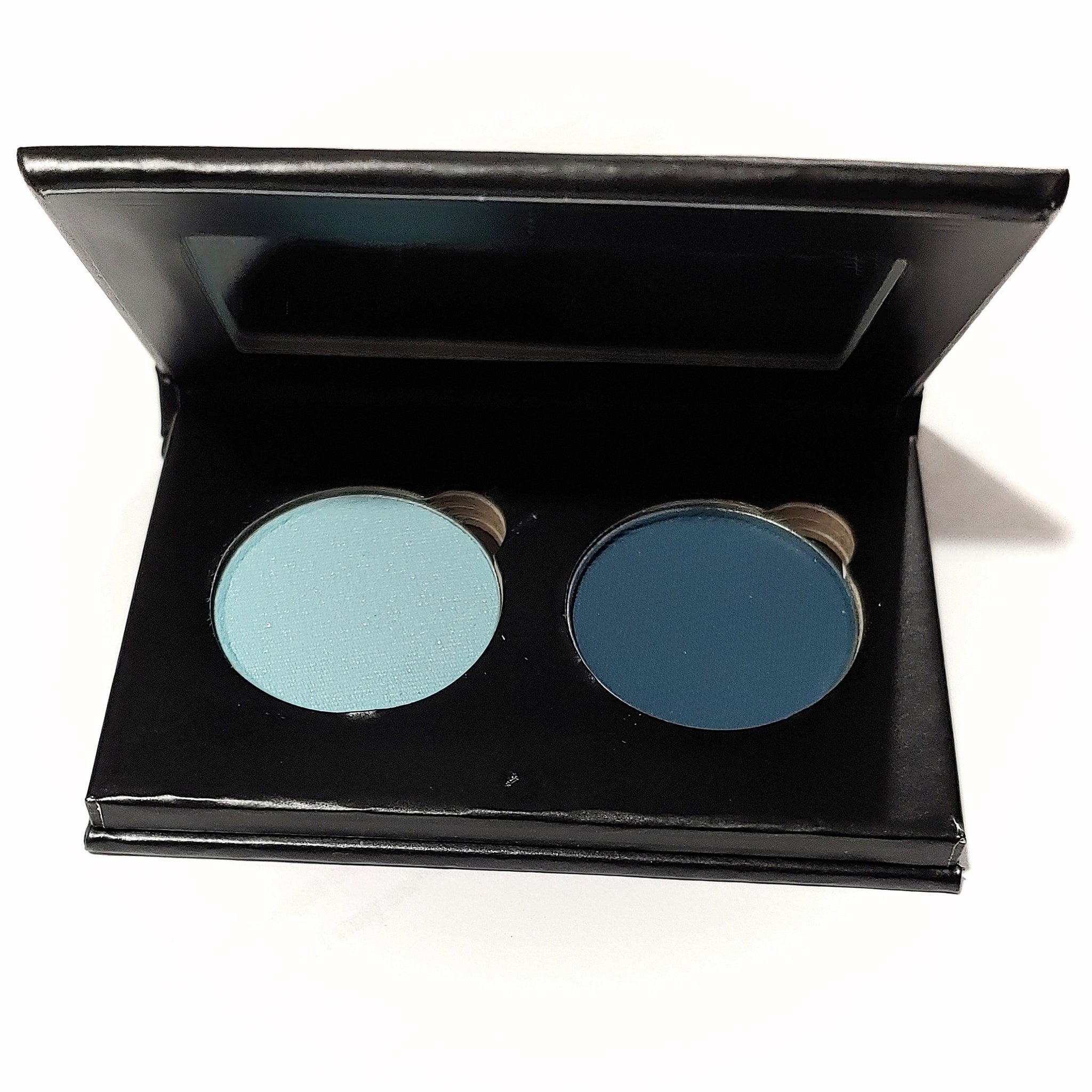 Pressed eye shadow duo with light blue and dark blue colors in a black palette