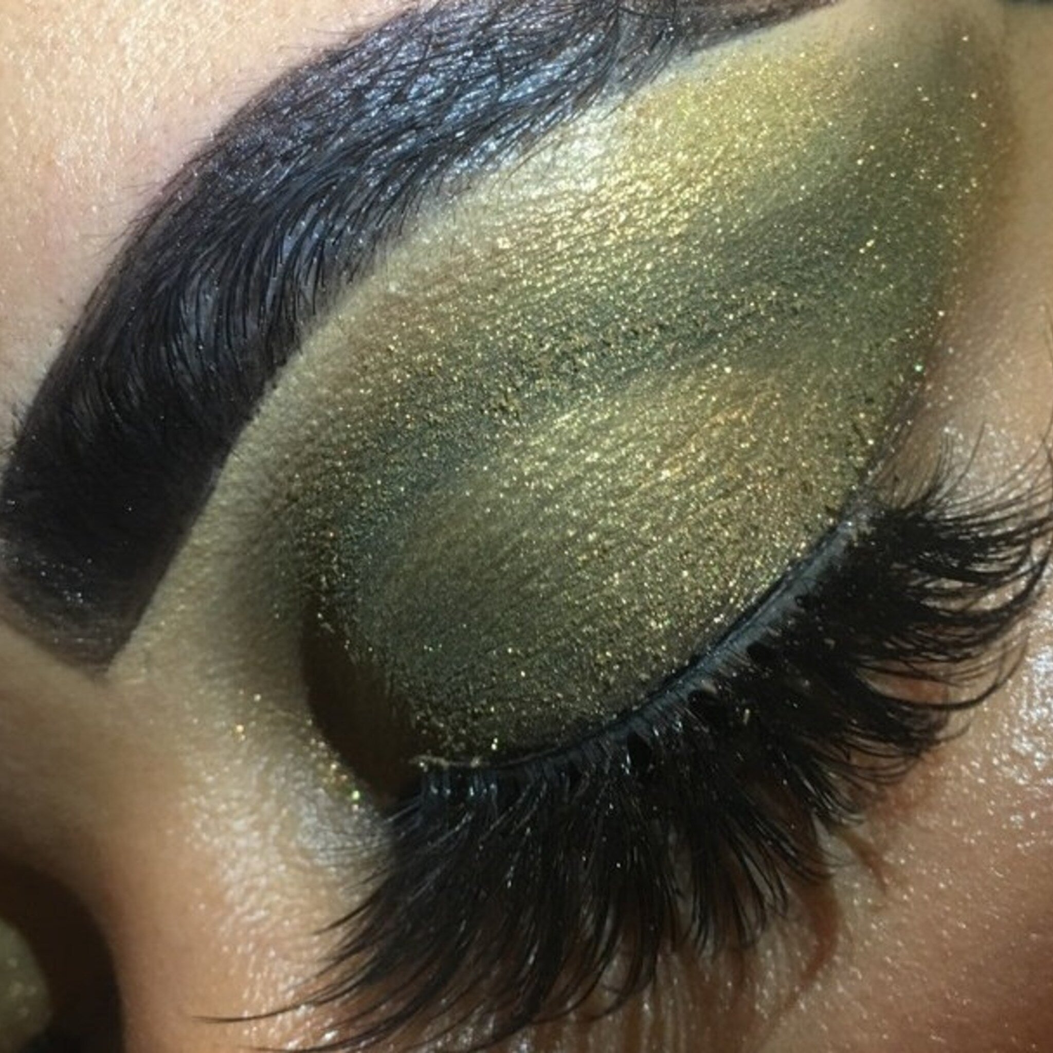 Side view of Beauty Realm Vegan Shimmer Eyeshadow in Amber Moss Shifter showing reflective metallic finish and compact case