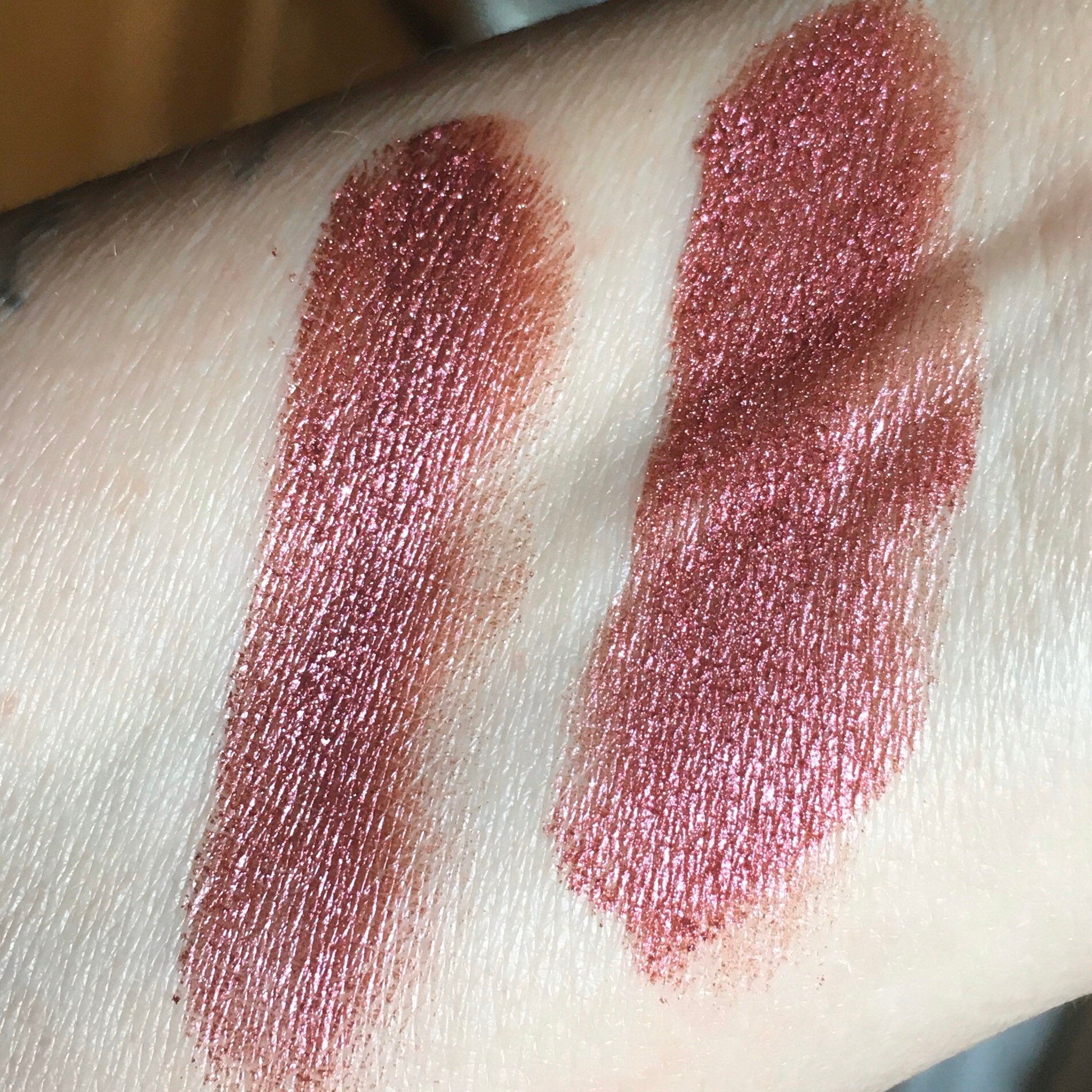 Side view of burgundy red raspberry vegan eyeshadow in sifter jar showing mineral luster texture