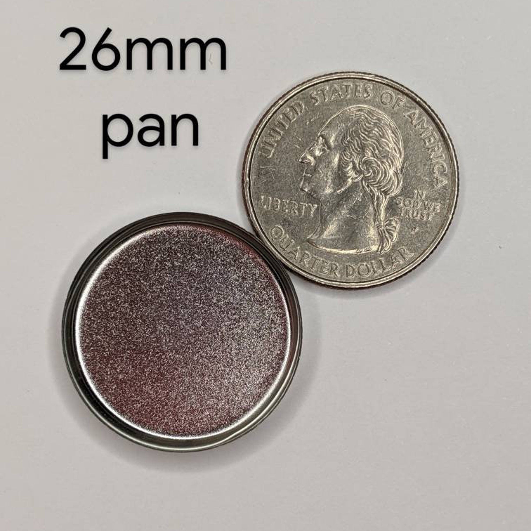 Side view of teal blue vegan pressed eyeshadow in compact showing smooth matte texture and rich pigment saturation