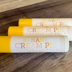 Lip balm tubes with yellow caps and white labels featuring "Banana Cream Pie" text