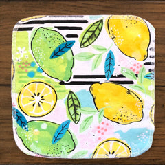 Cloth napkin with lemon fruit pattern, white edge stitching, and colorful design on fabric