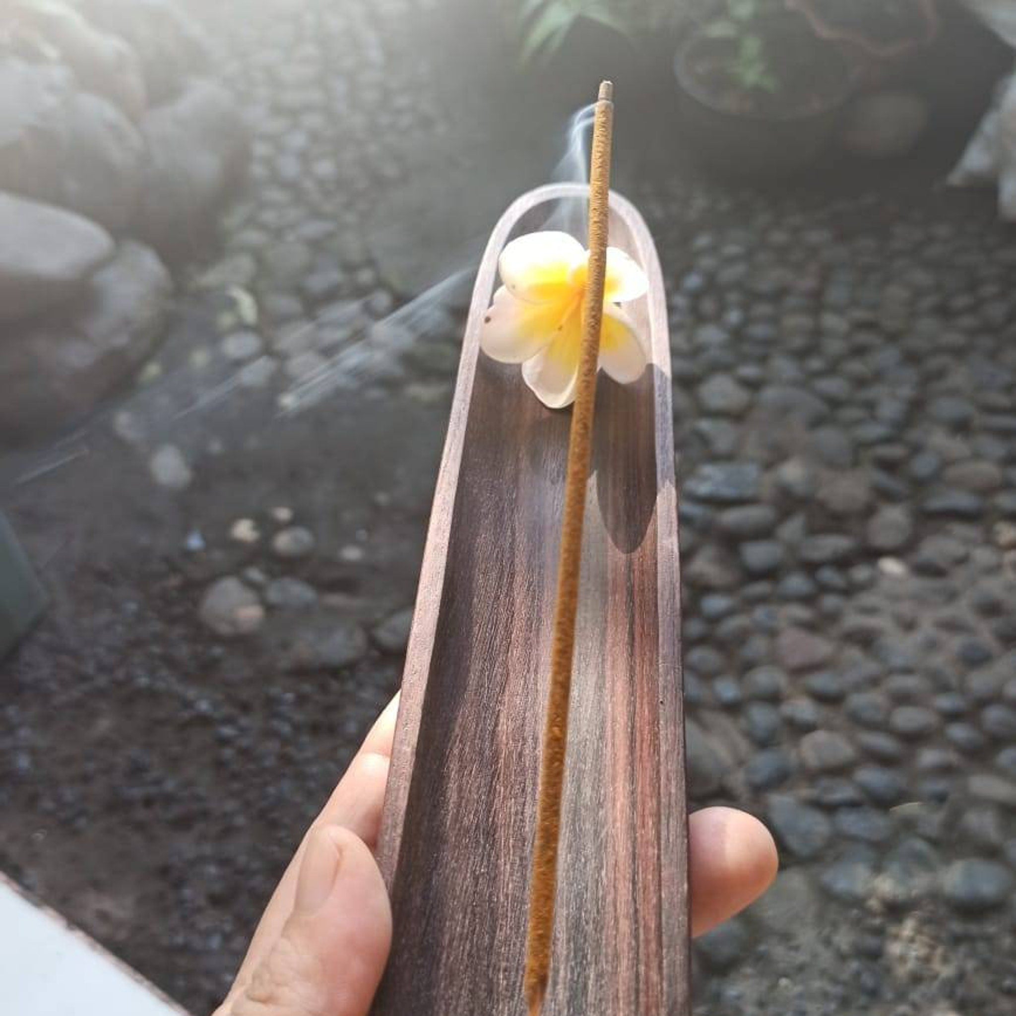 Incense stick with wooden holder, brown incense burning, flower decoration