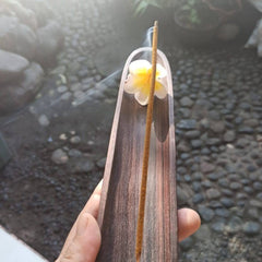 Incense stick with wooden holder, brown incense burning, flower decoration