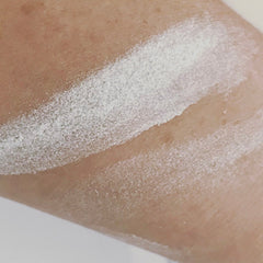 White powder applied on skin, showing texture and coverage on arm