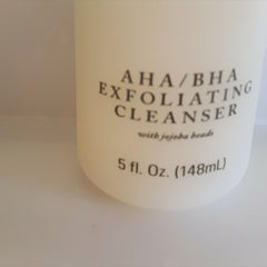 Exfoliating cleanser bottle, white with black text, AHA/BHA formula visible