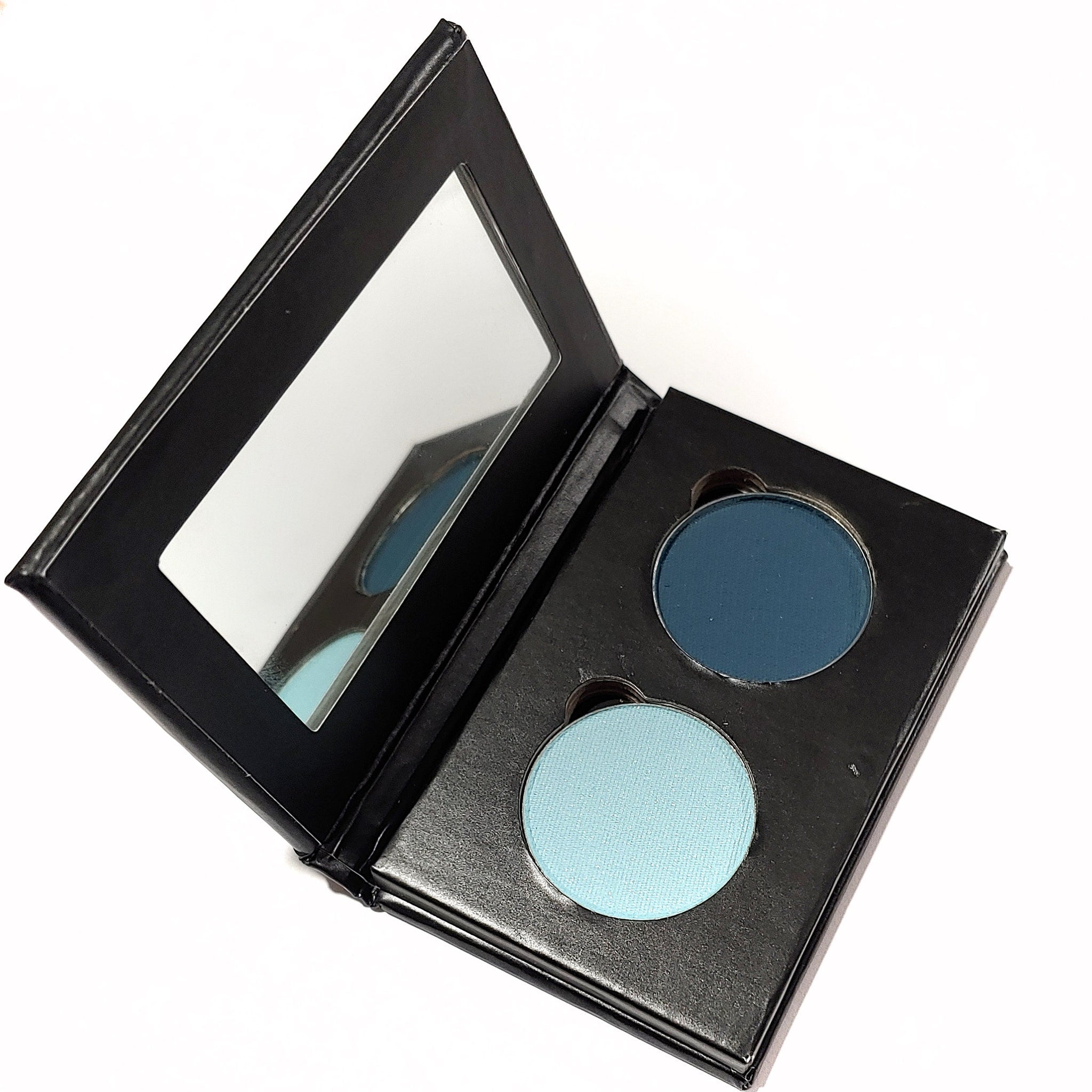 Eyeshadow palette with black case, mirror, and two round blue eyeshadows