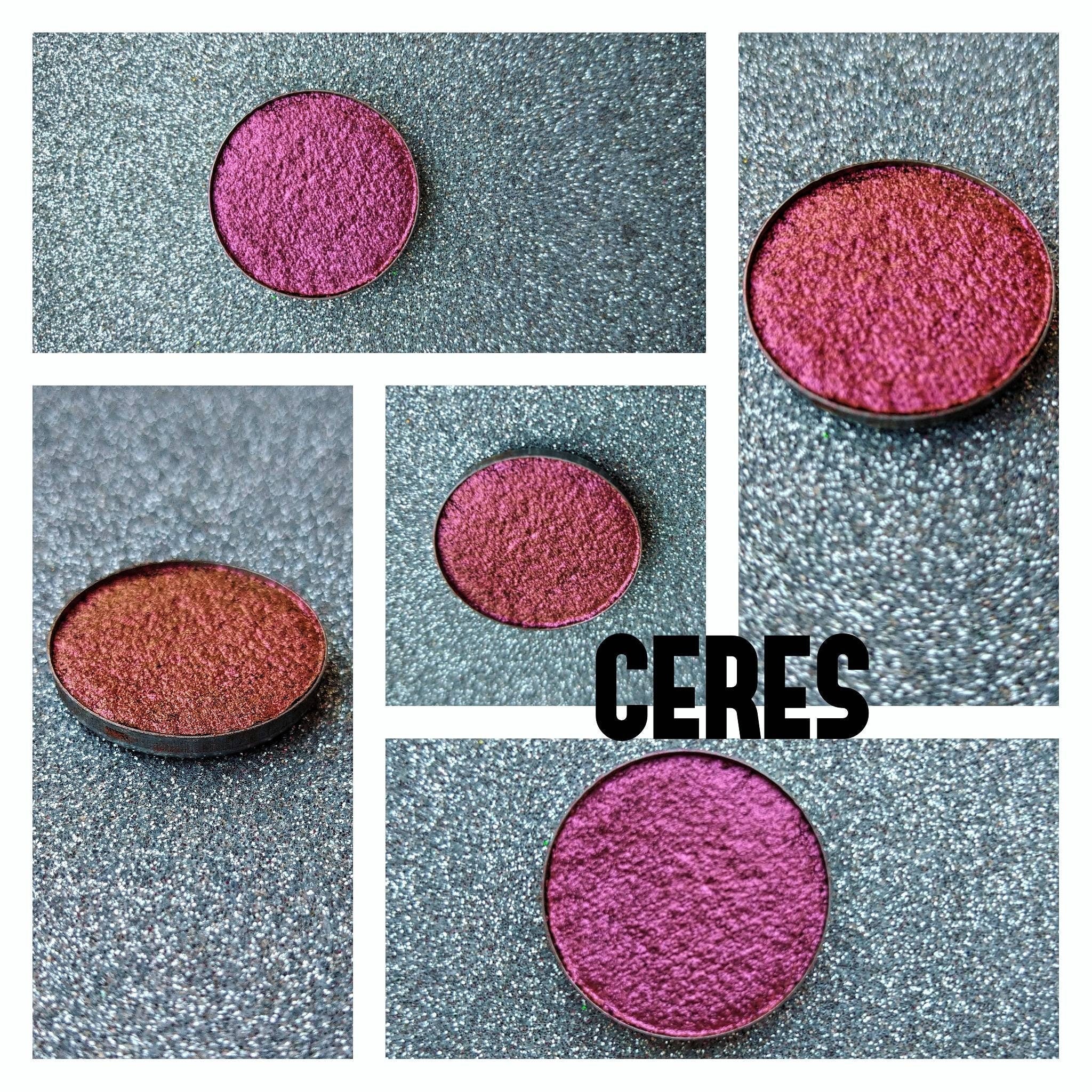 Close-up of NEBULA multichrome eyeshadow pan showcasing vibrant orange-pink-gold-violet shift in natural light