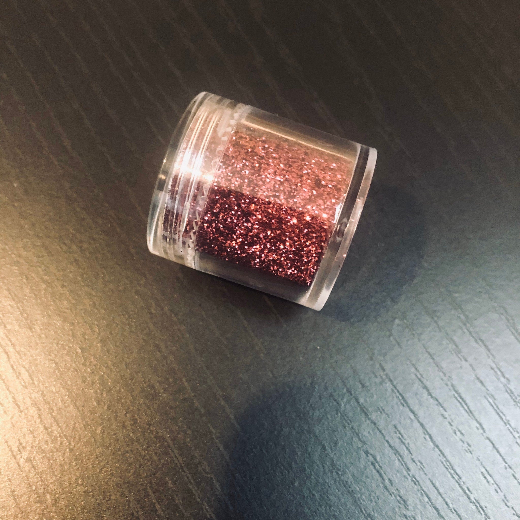 Close-up of pomegranate-hued pressed powder eyeshadow with satin finish in compact case