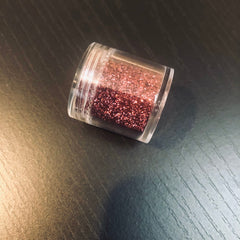 Close-up of pomegranate-hued pressed powder eyeshadow with satin finish in compact case